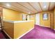 Finished basement landing with wood-beamed ceiling, vibrant yellow walls, and plum carpet at 2004 Spicers Ln, Woodstock, GA 30189