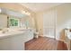 Bright bathroom features wood flooring, double vanity with ample counter space, and large, shuttered closet at 2004 Spicers Ln, Woodstock, GA 30189