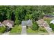 Aerial view of a suburban home with lush green lawn, mature trees, and a driveway with space for parking at 2004 Spicers Ln, Woodstock, GA 30189