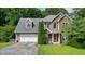 Charming two-story home featuring a stone and vinyl facade, two-car garage, and well-manicured lawn at 2004 Spicers Ln, Woodstock, GA 30189