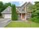 Charming two-story home featuring a stone and vinyl facade, two-car garage, and well-manicured lawn at 2004 Spicers Ln, Woodstock, GA 30189
