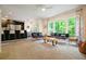 Spacious living room featuring a fireplace, large windows, and stylish furnishings, flowing into kitchen at 2004 Spicers Ln, Woodstock, GA 30189