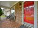 Inviting front porch of stone house with red door, seating, and views of the neighborhood at 2004 Spicers Ln, Woodstock, GA 30189