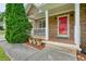 Inviting front porch of stone house with red door, white railing, and charming flower pots at 2004 Spicers Ln, Woodstock, GA 30189