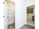 Hallway with pantry and access to laundry room featuring gray cabinets and tile floors at 2117 Ella Springs Dr, Covington, GA 30014