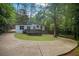 Charming single-story home with a well-manicured lawn, complementing the surrounding lush greenery and large driveway at 2575 Flagstone Se Dr, Atlanta, GA 30316