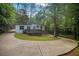 Charming single-story home with a well-manicured lawn, complementing the surrounding lush greenery and large driveway at 2575 Flagstone Se Dr, Atlanta, GA 30316
