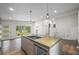 Open kitchen boasts a large island with sink and dishwasher, pendant lighting, and wood floors at 2575 Flagstone Se Dr, Atlanta, GA 30316