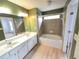 Well-lit bathroom featuring a dual sink vanity, tiled walls, and bathtub with a shower at 3613 Tinsley Sw Way, Atlanta, GA 30331