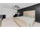 Spacious primary bedroom with a black accent wall, plush carpeting, and a ceiling fan at 3993 Makeover Ct, South Fulton, GA 30349