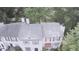 Aerial view of a two-story townhome featuring red awnings, a gray roof, and lush green trees at 1104 Huntington Se Trce, Smyrna, GA 30082