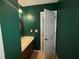Cozy half bathroom with a dark green wall and vanity with stylish lighting at 1104 Huntington Se Trce, Smyrna, GA 30082