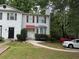 Charming two-story townhome with red shutters, a walkway, and well-maintained landscaping at 1104 Huntington Se Trce, Smyrna, GA 30082