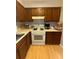 A kitchen with brown wood cabinets, light countertops, and a white range at 1104 Huntington Se Trce, Smyrna, GA 30082