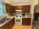 A kitchen with brown wood cabinets, light countertops, and a white range at 1104 Huntington Se Trce, Smyrna, GA 30082