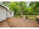Spacious wooden back deck with wood and iron railings overlooks a wooded area with lush green grass at 159 S Forest S Ave, Social Circle, GA 30025