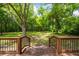 Wooden staircase leading from backyard deck to large, grassy, private backyard surrounded by mature trees at 159 S Forest S Ave, Social Circle, GA 30025