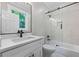 Stylish bathroom with white vanity, black fixtures, and tiled shower with sliding glass door at 159 S Forest S Ave, Social Circle, GA 30025
