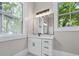 Bathroom featuring a white vanity with drawers, a large mirror, and a window with an outdoor view at 159 S Forest S Ave, Social Circle, GA 30025
