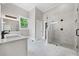 Bright bathroom with marble tile floor, a dual vanity and tiled shower featuring glass doors at 159 S Forest S Ave, Social Circle, GA 30025