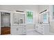 Bright bathroom with dual vanities, modern lighting, and a view to a comfortable fireplace at 159 S Forest S Ave, Social Circle, GA 30025