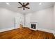 Bedroom with hardwood floors, a fireplace, ceiling fan, and connecting rooms via white doors at 159 S Forest S Ave, Social Circle, GA 30025