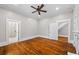 Bedroom with hardwood floors, a fireplace, ceiling fan, and connecting rooms via white doors at 159 S Forest S Ave, Social Circle, GA 30025