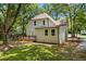 Two-story home with a large back deck surrounded by mature trees and lush green grass at 159 S Forest S Ave, Social Circle, GA 30025