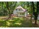 Back of home showing wooden deck with stairway to a large, grassy, private backyard surrounded by mature trees at 159 S Forest S Ave, Social Circle, GA 30025