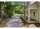 Side view of the home featuring a covered porch, stone driveway, and landscaped yard at 159 S Forest S Ave, Social Circle, GA 30025