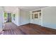 Inviting covered front porch with beautiful wood flooring and entry door at 159 S Forest S Ave, Social Circle, GA 30025