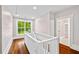 Bright hallway with hardwood floors, a view of the yard, and a peek into a room with built in shelves at 159 S Forest S Ave, Social Circle, GA 30025