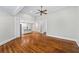 Open-concept living room with hardwood floors and view to the modern kitchen and stairway at 159 S Forest S Ave, Social Circle, GA 30025