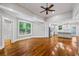 Open-concept living room with hardwood floors, ceiling fan, and access to a modern kitchen at 159 S Forest S Ave, Social Circle, GA 30025