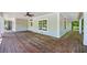 Spacious, wrap-around porch with natural stained wood flooring and white columns at 159 S Forest S Ave, Social Circle, GA 30025