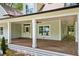 Spacious covered porch with stylish columns, ceiling fan, and wood flooring at 159 S Forest S Ave, Social Circle, GA 30025