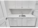 Modern laundry room featuring white cabinets, sink, countertop, and stainless steel appliances at 2520 Peachtree Nw Rd # 403, Atlanta, GA 30305