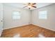 Bedroom features hardwood floors, neutral walls, and a ceiling fan at 1526 Tanglewood Nw Way, Conyers, GA 30012