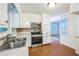 Functional kitchen featuring stainless steel appliances, white cabinets, and a view into an adjacent living area at 1526 Tanglewood Nw Way, Conyers, GA 30012