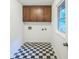 Laundry room with overhead cabinets and black and white checkered floor at 1526 Tanglewood Nw Way, Conyers, GA 30012
