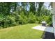 A view of the backyard and tree line including a grill on a concrete pad at 160 Winner St, Acworth, GA 30102