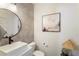 Stylish powder room featuring a vessel sink, round mirror, modern faucet, and decorative artwork at 160 Winner St, Acworth, GA 30102