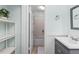 Well-lit bathroom with a sink vanity and view of a white-tiled shower at 1701 Wiscasset Pl, Tucker, GA 30084