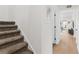 Hallway with neutral carpet on staircase and view into the living room with stylish decor at 1701 Wiscasset Pl, Tucker, GA 30084