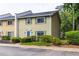 Charming townhome with green and tan siding, well-maintained landscaping, and green shutters at 1701 Wiscasset Pl, Tucker, GA 30084
