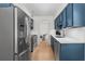 Modern kitchen featuring blue cabinets, stainless steel appliances, and a seamless transition to the living space at 1701 Wiscasset Pl, Tucker, GA 30084