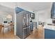 Open-concept kitchen with stainless steel appliances and blue cabinets that look out to dining and living room at 1701 Wiscasset Pl, Tucker, GA 30084