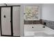 Clean bathroom with glass-enclosed shower and soaking tub by window at 5123 Jack Dr, Decatur, GA 30035