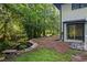 Landscaped backyard with a seating area and access to the house at 1582 Pine Cir, Austell, GA 30168