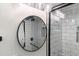 Bathroom with round mirror over pedestal sink, shower with subway tile and glass door at 1582 Pine Cir, Austell, GA 30168